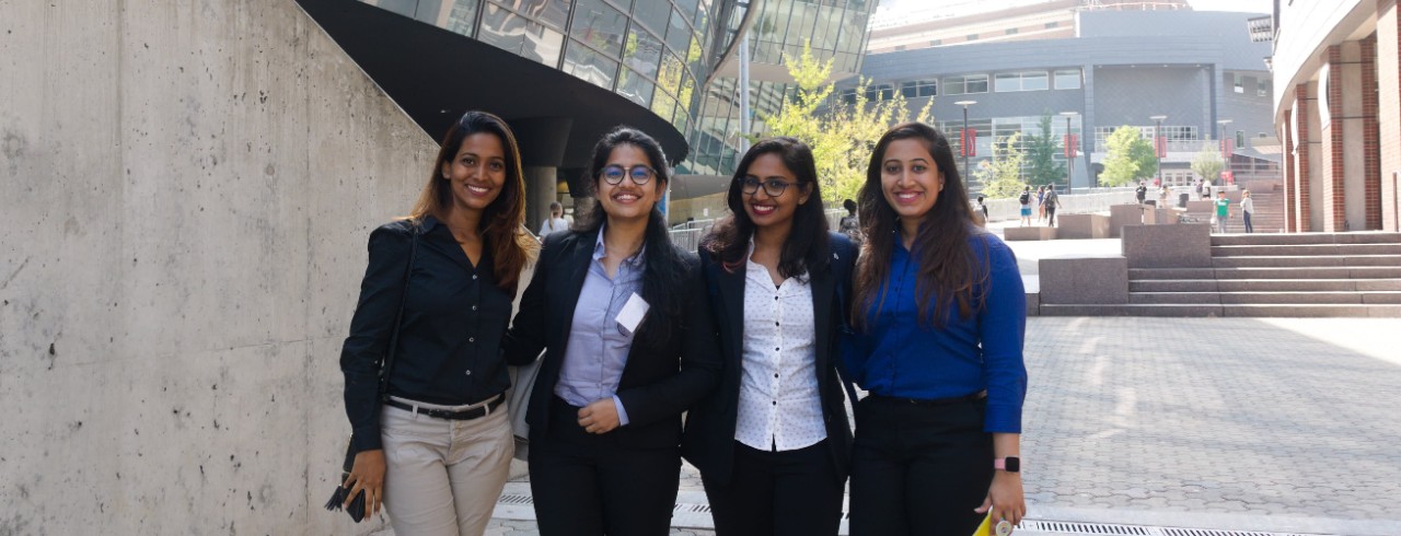 Four international students stand together on UC's MainStreet.